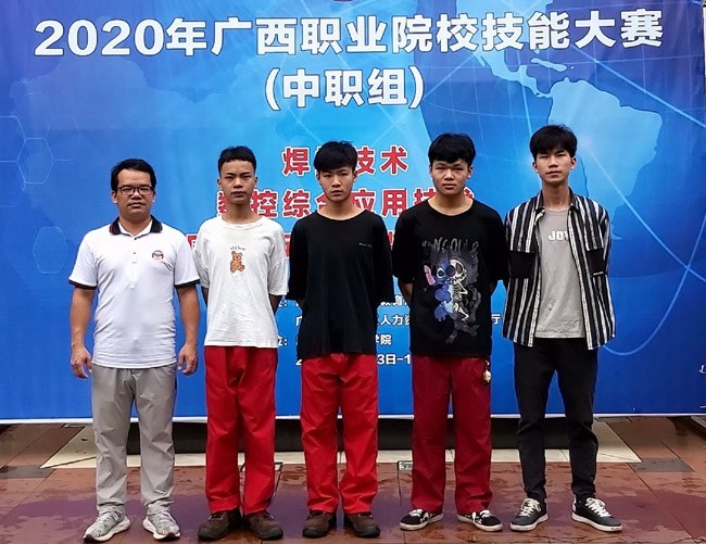覃業(yè)彬老師（左一）和參加數(shù)控綜合應用項目技能競賽的學生們.jpg